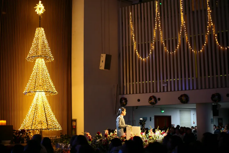 A Christian woman performed a piano solo on a spotlight-lit stage adorned with a striped Christmas tree at Haidian Church in Beijing on December 25, 2024.