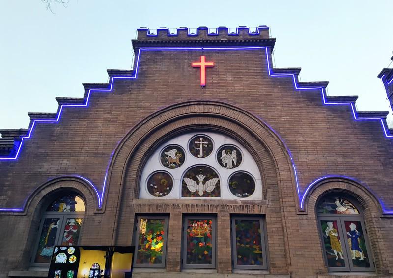 The exterior of Chongwenmen Church is illuminated with light strips, and the cross shines brightly.