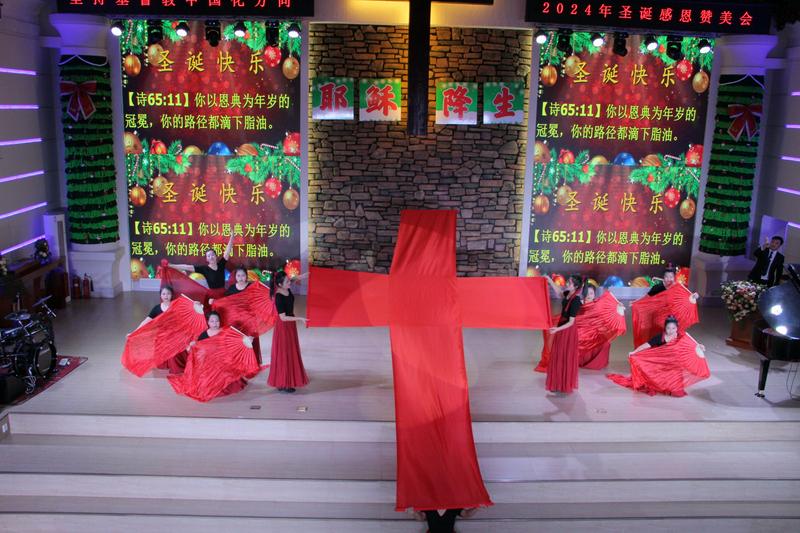 Christians in festive costumes performed a dance centered around a red-cloth cross on stage to celebrate Christmas at Yingkou Church in Yingkou City, Liaoning Province, during Christmas week 2024.