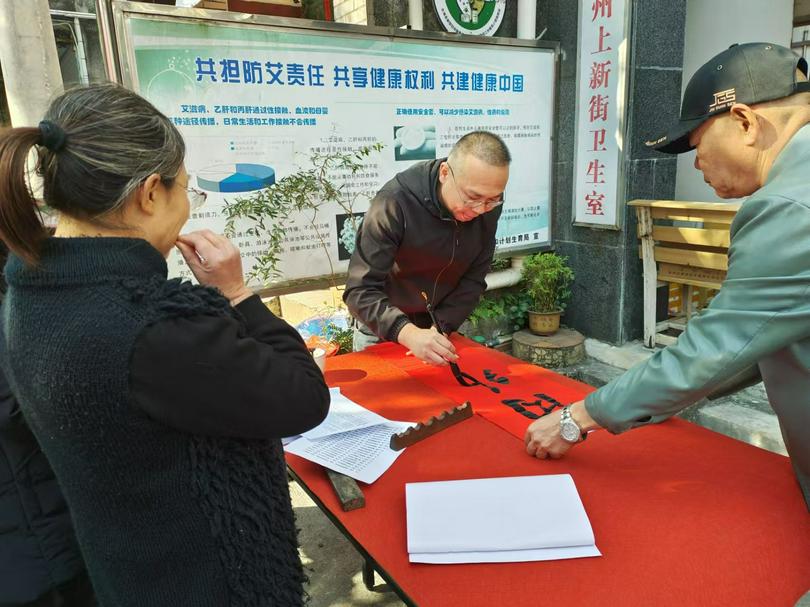 A calligrapher composed Spring Festival couplets while attendees admired his skill at a couplet writing and gifting event held at Hepu County Church in Beihai City, Guangxi Zhuang Autonomous Region, on January 11, 2025.