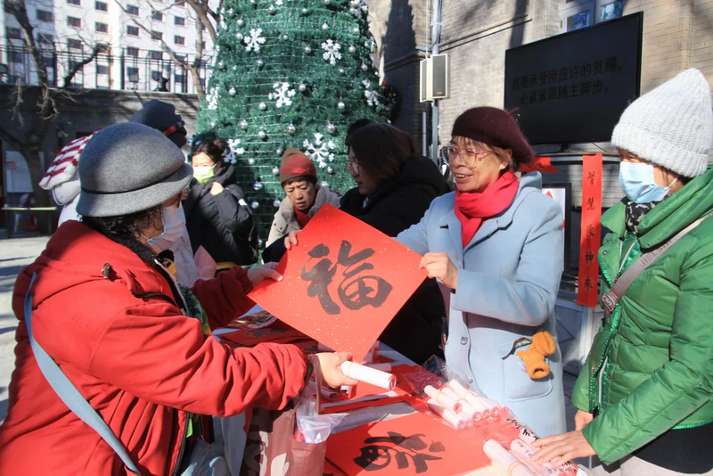 A Christian woman presented the character "Fu" (blessing) to a participant at a Spring Festival couplets and "Fu" character writing and gifting event in Beijing during the Chinese New Year.