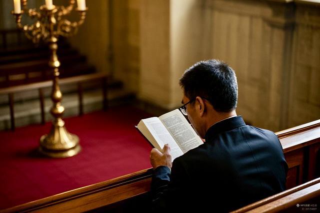 A man reads a book at a church.