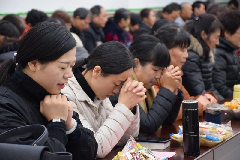 Believers prayed at a gathering on an unknown day.