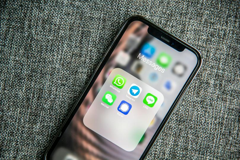 A black iPhone with the screen on, displaying the Messages app interface