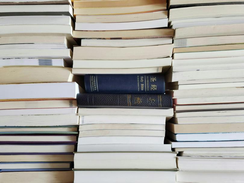 Two Chinese bibles are in a stack of books.
