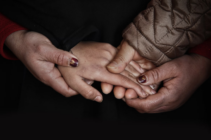 Four hands hold together.