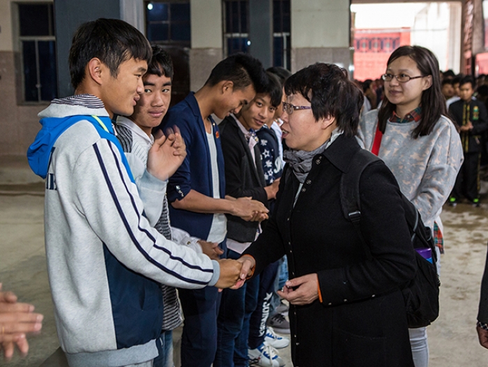 Rev. Bian Wenai shakes hands with the students of Baoshan Bible School of the Nations