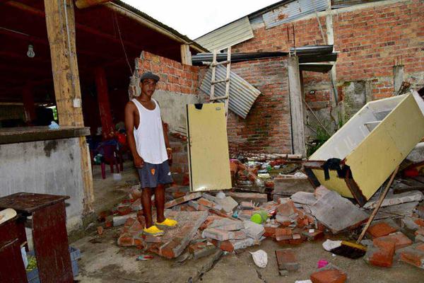A villager is standing on the debris of his collapsed house