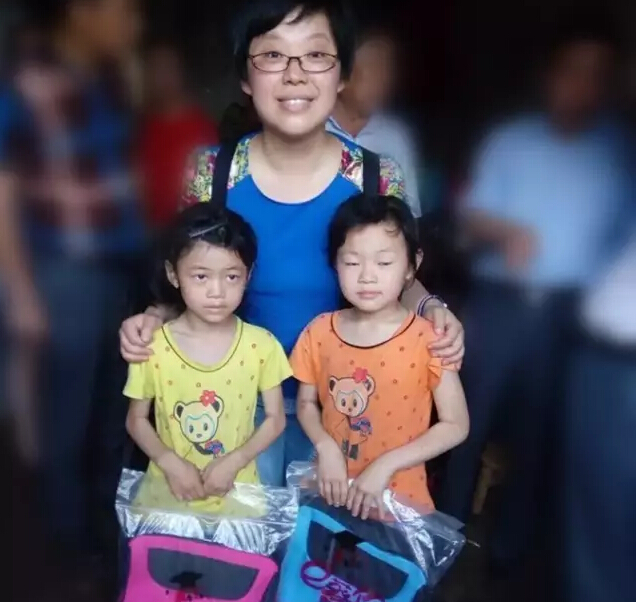 A couple of cute sisters receive schoolbags 