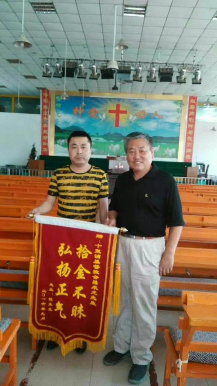 Lv Laihu(left)received the pennant from the hand of Zhen(right), the owner, in Shilipu Church