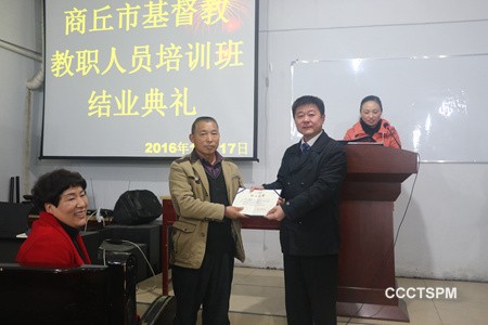 A trainee receives the certificate at the commencement of the leadership traning class 
