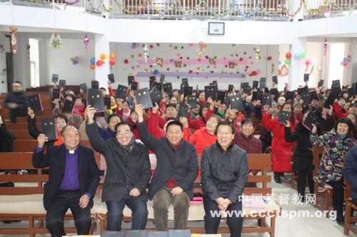 Rev. Shan (Left 3 in the first row) holds the Bible with the congregation  in Gujiaxiang Church 