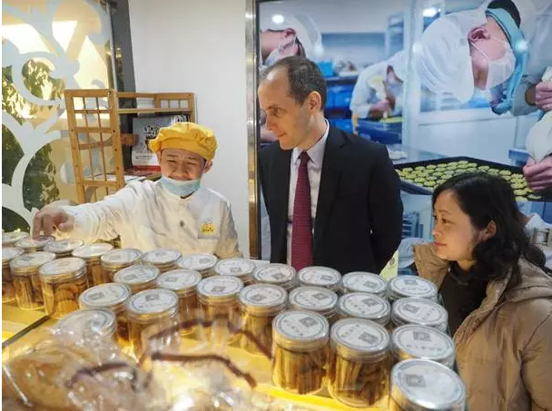 A co-worker of the Amity Bakery introduces deserts to Hanscom Smith, the United States’s Consul-General in Shanghai