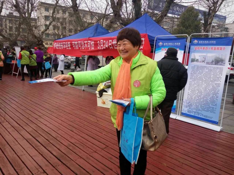 A member of "Home of Love" Fellowship in Yiyang distributes brochures to people passing by 