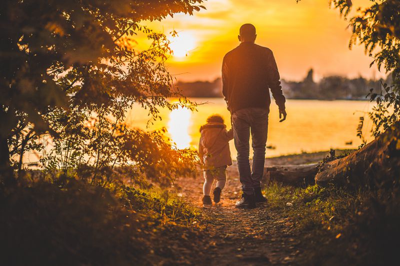 A father walks with his child to the lake 
