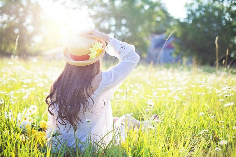 A woman sits on the grass. 