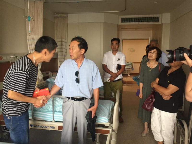 The team from Longyou County visited Xu Guojun (left) and his daughter in a hospital. 
