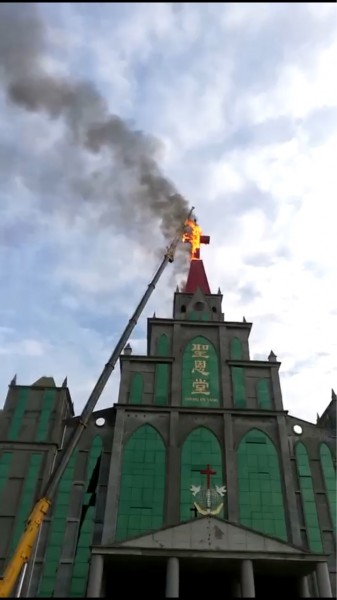 The cross of the Holy Grace Church set on fire. 