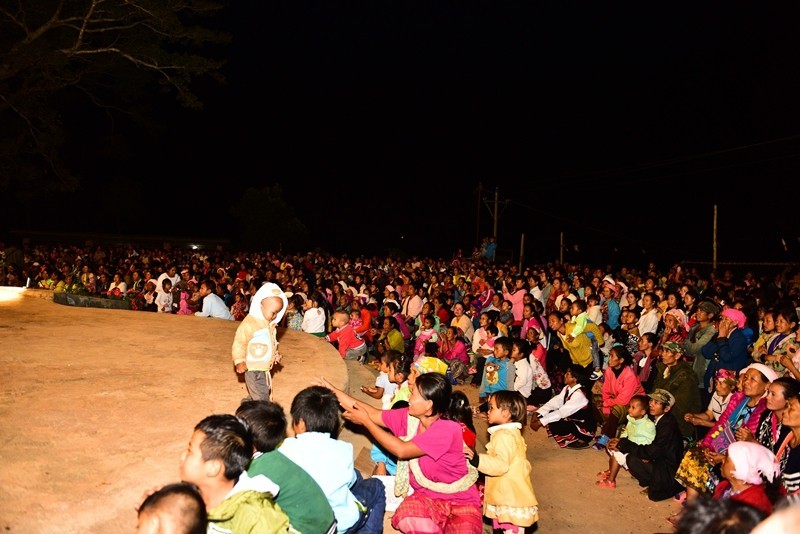 Thanksgiving day of Laku people Believers watching the dancing, seated in the church yard.