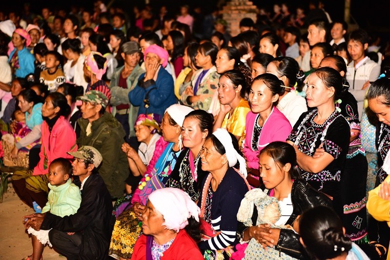 Thanksgiving day of Laku people Believers watching the dancing, seated in the church yard.