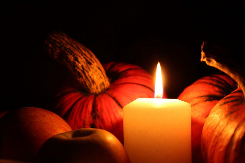 A candle lights among vegetables. 