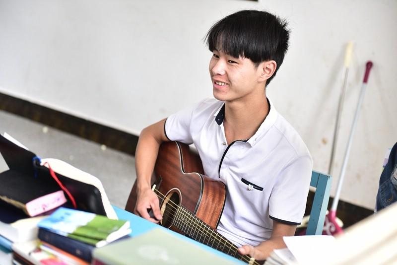 A student plays a guitar to praise God.