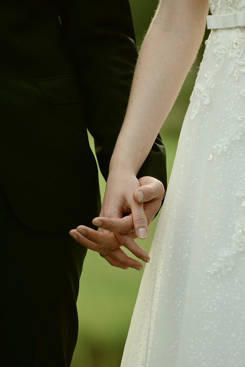 A couple holds hands. 