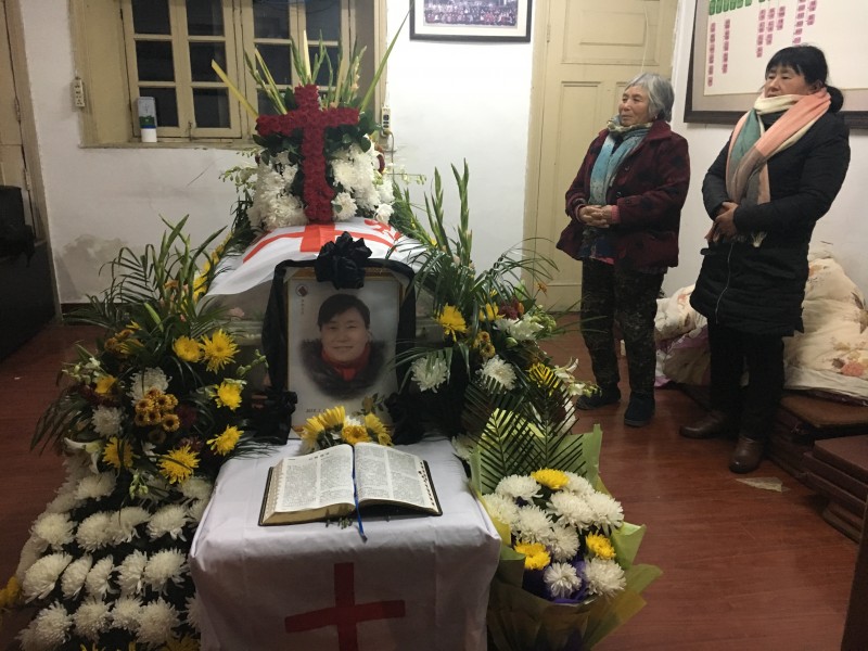 An open Bible was placed in front of the portrait and body of Rev. Cheng Baixia. 