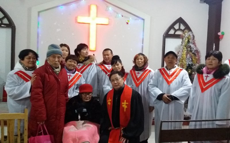 Grouo photo: Lei Shuqun (in the wheelchair),102, the choir, and her pastor after the baptism service 