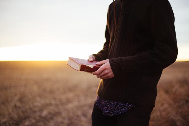 A man holds a bible in his hands. 