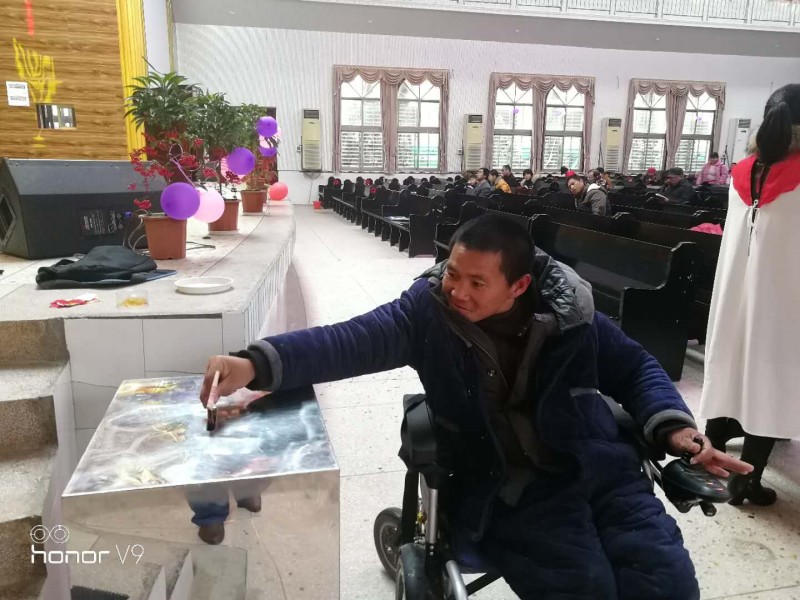 A disabled man gave his donation in the offering box of Yugan Guankou Church to support Jiangxi Bible School on Feb. 25, 2018.