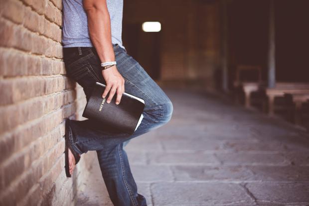 A man holds a bible in his hands. 