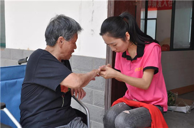 A female volunteer trimmed a leprosy survivor's nails on June 16, 2018. 