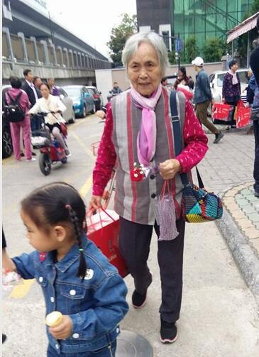An elderly woman receive a bonquet and a set of bedding from Hangzhou Chengbei Church, Oct. 14, 2018.