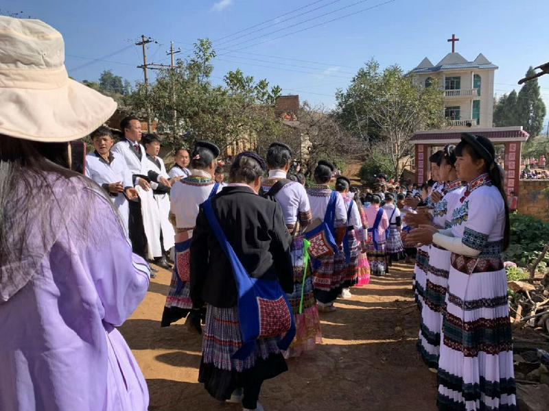 Miao believers walked to the church while other members stood in two lines to welcome them. 