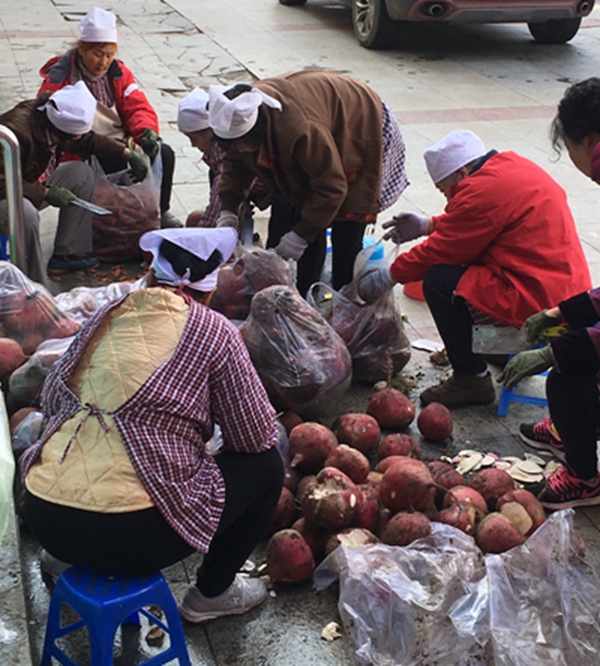 Christian women sorted out vegetables in front of a church.