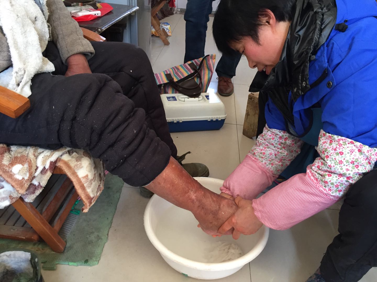 Sister Zhang washed the feet of an old survivor. 