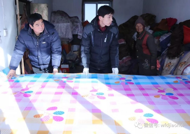 The workers of the Good Smaritan Charity Ministry replaced a new bedding at a house of a destitute family, Wangfang, Liaoning, Jan. 31, 2019. 