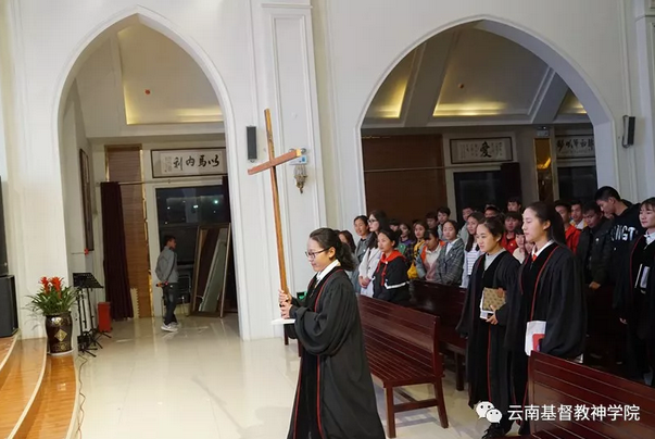 A woman held a cross high in her hands in the service hosted in Yunnan Theological Seminary, Mar. 1, 2019.