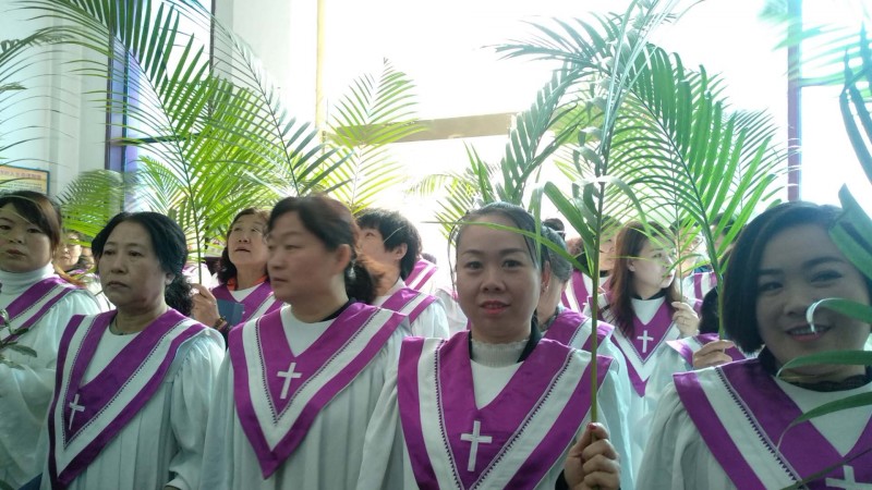 The choir members of Shanxi Linfen Church walked into the church with palm branches on April 14, 2019. 