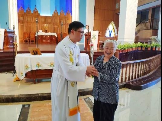 On May 12, 2019, a pastor gave a carnation to an old lady in Zhenli Church of Lianjiang, Fujian.