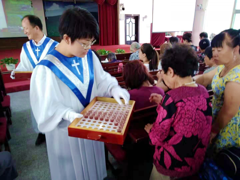 A pastor distributed the bread and cup to the congregation of Lühuajie Church, Anshan, Liaoning, on Sept 1, 2019. 