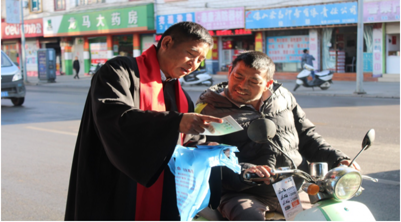 A pastor shows a motorcyclist the AIDS prevention booklet in Baoshan, Yunnan province, on Nov. 30, 2019. 