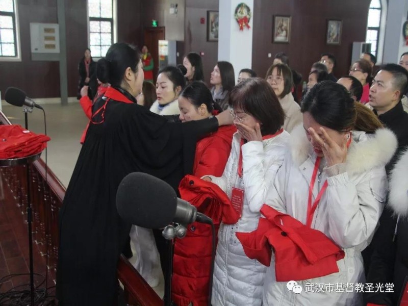 A pastor granted choir attire to a sister during the commissioning service held in Wuhan Shengguang Church on Dec. 22, 2019. 