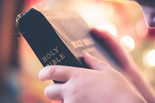 A man holds the Bible in his hands. 