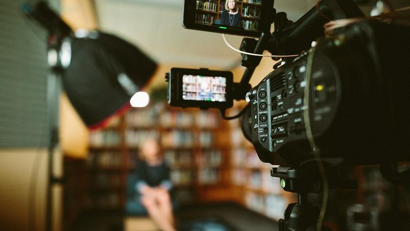 A video camera records a talking program. 