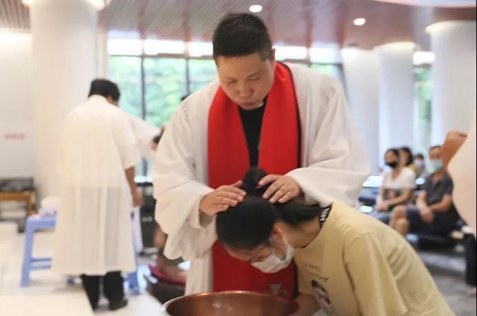 A pastor of the Flower Lane Church baptized a woman at the annusal summer baptism service in Fuzhou, Fujian, on August 29, 2020. 