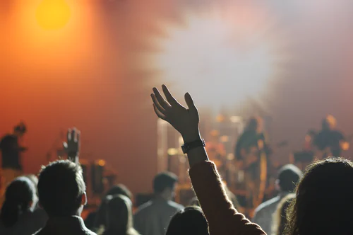 People sing and praise God in a worship service. 