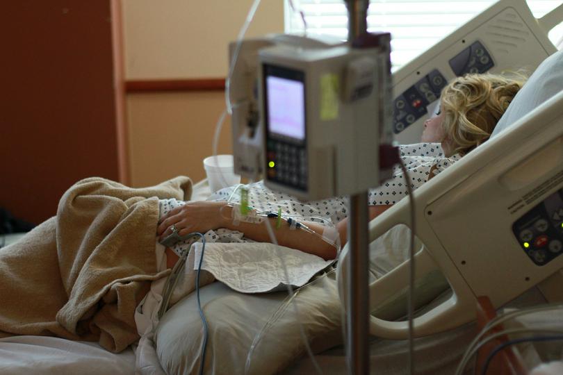 A woman in a hospital bed. 