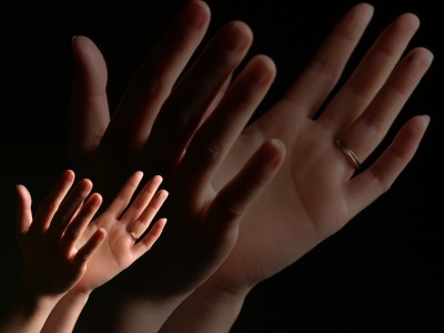 Big and small hands are raising up to worship God.